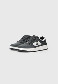 Para ciemnoszarych i białych niskich sneakersów z czarnymi sznurówkami oraz stylizowanym logo "C" po bokach, na jasnoszarym tle.