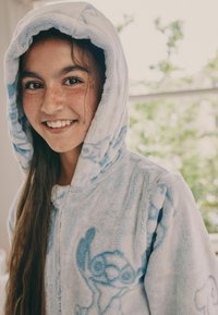 Blaues Plüsch-Hoodie mit weicher Textur, das auf der Vorderseite ein Cartoon-Charakterdesign und eine große Kapuze aufweist.