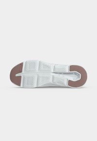 Semelle d’une chaussure de sport blanche avec des parties en caoutchouc marron texturé au talon et à l’orteil pour l’adhérence, affichée sur fond blanc.