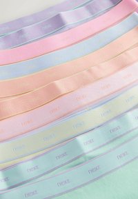 Mehke pastele tkaninske trakove, položene ena ob drugo, vsak z večkrat vtisnjenim izrazom "next" v ujemajočih odtenkih.