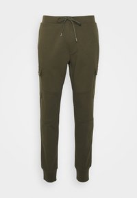 Olivgröna sweatpants med justerbar dragsko, tapered byxben och sidofickor. Tillverkade av ett mjukt, strukturerat tyg.