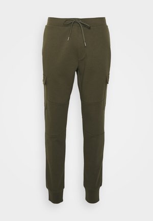 Olivgröna sweatpants med justerbar dragsko, tapered byxben och sidofickor. Tillverkade av ett mjukt, strukturerat tyg.