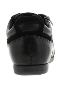 Zapato de vestir de hombre en cuero negro y ante visto desde la parte trasera, con una costura cosida y un tacón bajo.