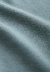 Gaiši zils audums ar gludu, mīkstu tekstūru. Materiālam ir smalki adījuma raksti un matēta virsma, kas norāda uz stiepjamību un komfortu.