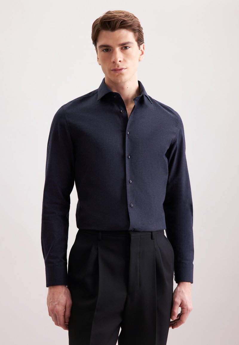 Granatowa, długosleeve koszula zapinana na guziki z ustrukturyzowanym kołnierzykiem, gładką fakturą i dopasowanymi ciemnymi guzikami; w połączeniu z dopasowanymi czarnymi spodniami.