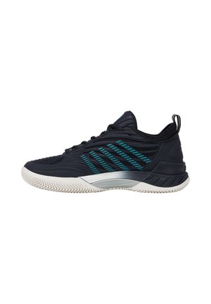 Basket de sport noire avec des bandes latérales turquoise, semelle blanche texturée et languette à talon, vue de profil.
