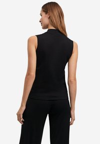 Zwarte mouwloze top met een hoge halslijn, gemaakt van een gladde, elastische stof. De aansluitende snit accentueert de vorm van het lichaam.