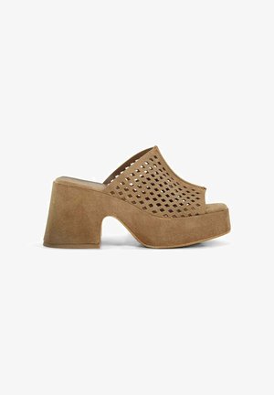Mule ouverte marron en daim avec talon bloc et dessus perforé à motif losange, montrée de profil sur fond blanc.