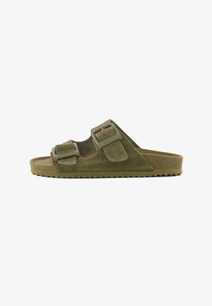 Klizni sandale od maslinasto zelene brušene kože s dvije podesive remenčiće s kopčama i nazubljenim potplatom.