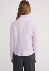 Lila sweater met een geribde col en zoom. Zachte textuur, lange mouwen en een relaxte pasvorm. De achterkant toont een glad, minimalistisch ontwerp.