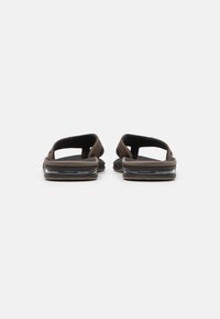 Brune sandaler med åpen bak, justerbare stropper, gummisåler og gjennomsiktig luftdemping på hælen. Flat og teksturert fotseng.