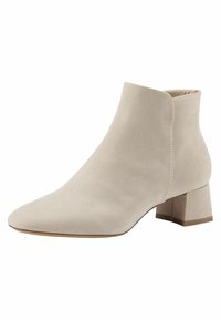 Botas de tobillo de gamuza beige con punta afilada, tacón de bloque de altura media y textura suave. Presentan costuras mínimas y un diseño elegante.