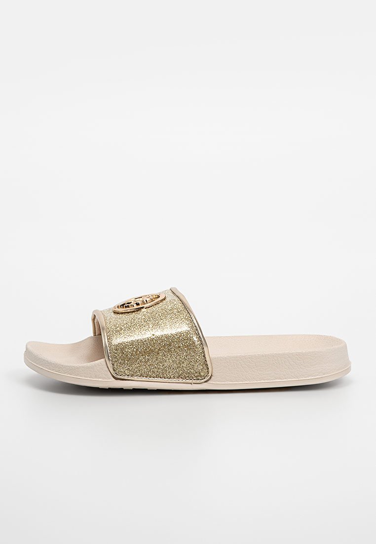 Gold glitzernde Rutsch-Sandale mit breitem Riemen und einem runden Logo-Detail. Beige Oberfläche mit strukturiertem Sohle für besseren Halt.