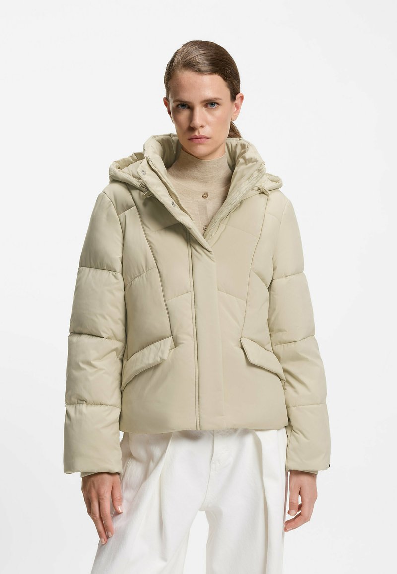 Beige pufferjakke med hætte, med lynlås foran, quiltet design og sidelommer, lavet af skinnende, glat stof.