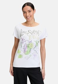 Biała koszulka z krótkim rękawem z kolorową grafiką "Lime Splash Lemonade" z ilustracjami limonek i lawendy, w luźnym kroju.