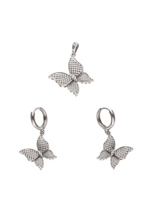 Pendente a forma di farfalla in argento e orecchini a cerchio abbinati con ali testurizzate su sfondo bianco.