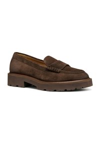 Bruine suède loafer met een gestikte detail op de schacht, een brede platte zool en een licht gestructureerde rubberen loopzool voor grip.