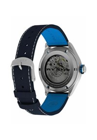 Timex pulkstenis ar sudraba nerūsējošā tērauda korpusu, melnu caurspīdīgu aizmuguri, tumši zilu ādas siksniņu un zilo akcentu. Apaļa forma, redzama kustība.