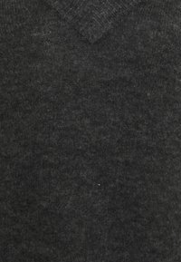 Pull en V gris foncé en laine douce, avec une surface texturée et des variations subtiles d'ombre, offrant une coupe classique.
