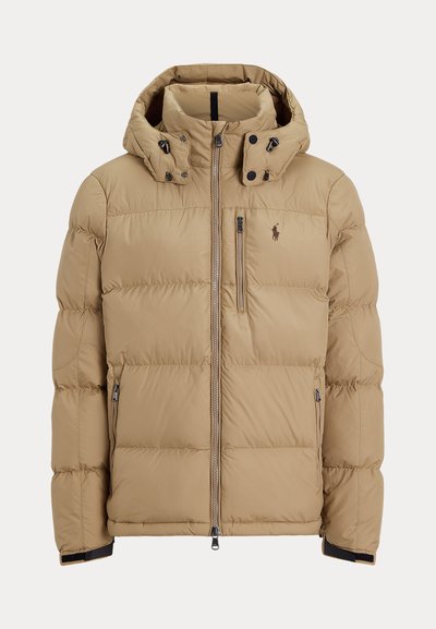 Béžová prešívaná zimná bunda s kapucňou, celým predným zipsom, dvoma bočnými vreckami na zips a logom na ľavej strane hrude.