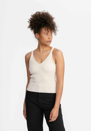 Geribbelde, off-white tanktop met een V-hals en dunne bandjes; gecombineerd met gestructureerde zwarte broek. Gladde brei-stof met een getailleerd silhouet.