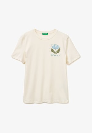 Camiseta cremosa de manga corta con cuello redondo, con gráfico de flor azul y texto "bloom" en el lado izquierdo del pecho.