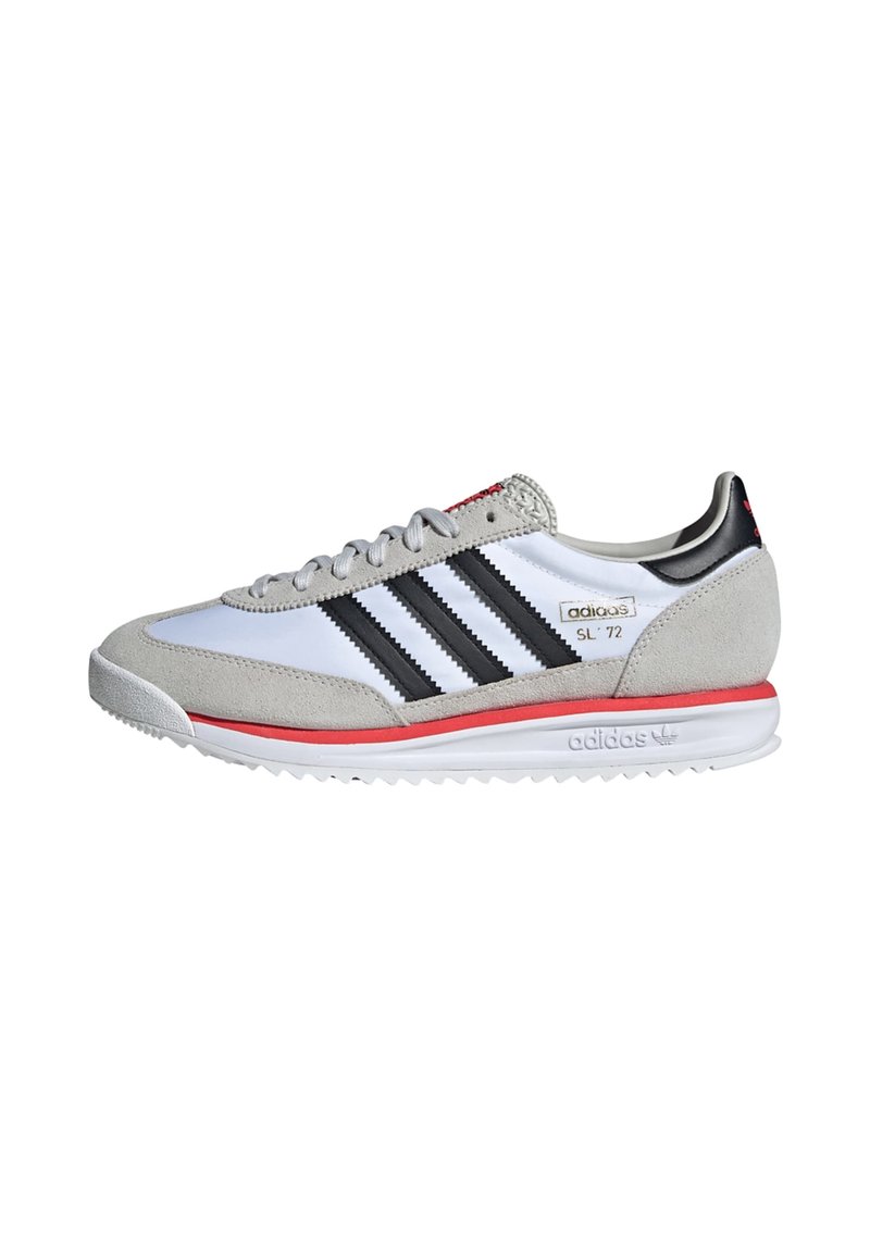 Witte sneaker met grijze nubuck accenten, zwarte strepen, rode details en een gestructureerde rubberen zool. Voorzien van een gewatteerde kraag en veters.