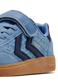 Niebieskie tenisówki wykonane z teksturowanej skóry i siateczki, z paskiem na rzep, kontrastowymi granatowymi akcentami oraz gumową podeszwą z detalem logo.
