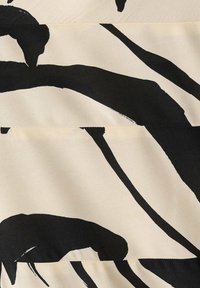 Tissu beige avec un grand motif abstrait de coups de pinceau noirs formant des formes courbes et angulaires irrégulières.