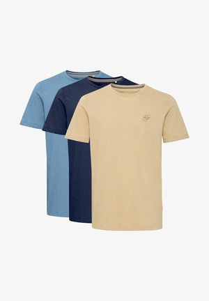 Tres camisetas de manga corta en azul claro, azul marino y beige. Tejido de algodón suave con un escote redondo y un pequeño logo en la camiseta beige.