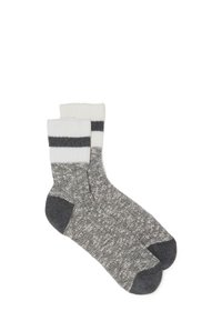 Gestrickte graue Socken mit einem strukturierten Design. Weißer gerippter Bund mit zwei dunkelgrauen Streifen. Dunkelgraue Akzente an Ferse und Zehen.