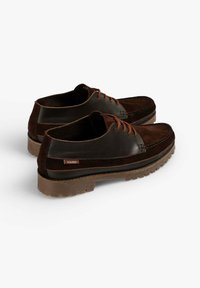 Zapatos de cuero y ante marrón con cordones naranjas, suela resistente y una etiqueta de marca. Punta redondeada y detalles de costura en la parte superior.