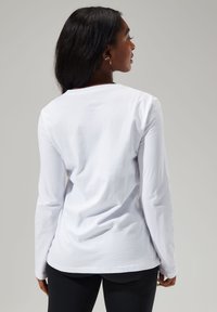 Weißes Langarm-T-Shirt mit Rundhalsausschnitt und lockerem Schnitt. Weicher Baumwollstoff, schlichtes Design und glatte Textur.