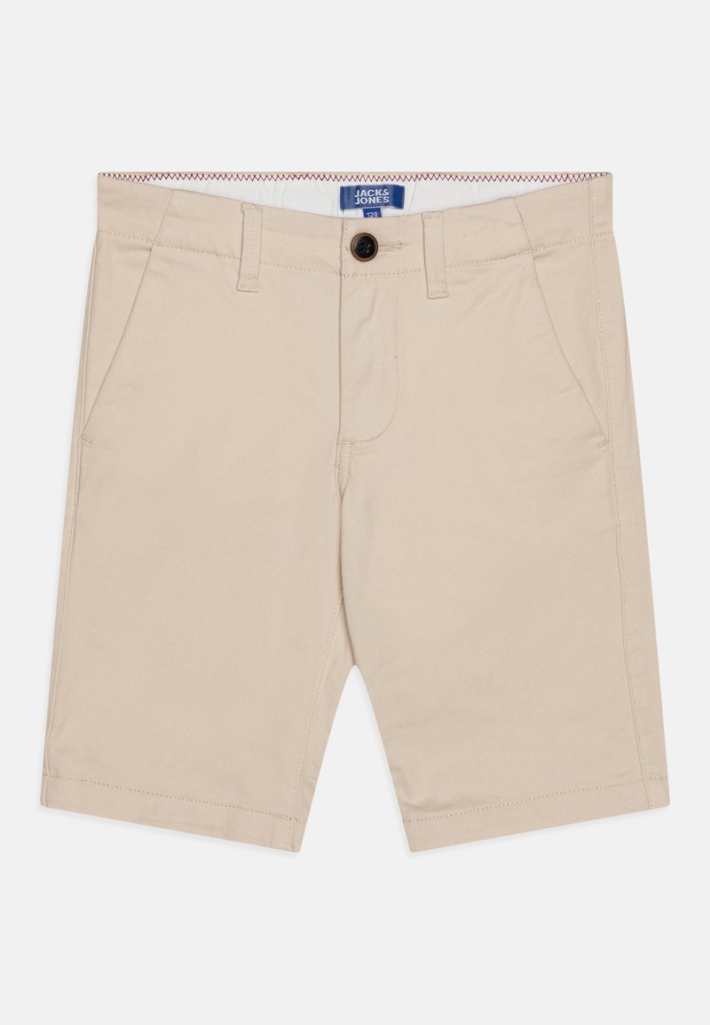 Shorts en coton beige avec une fermeture à bouton, des poches latérales et une texture lisse. Présente une étiquette de marque bleue à l'intérieur de la taille.