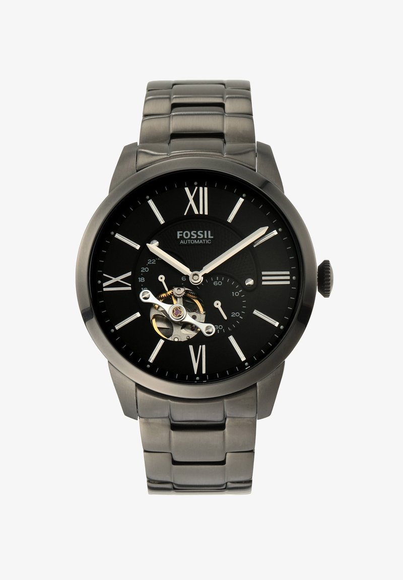 Relógio automático preto com acabamento em prata, numerais romanos, fundo transparente que exibe o movimento e uma bracelete de link de aço inoxidável.