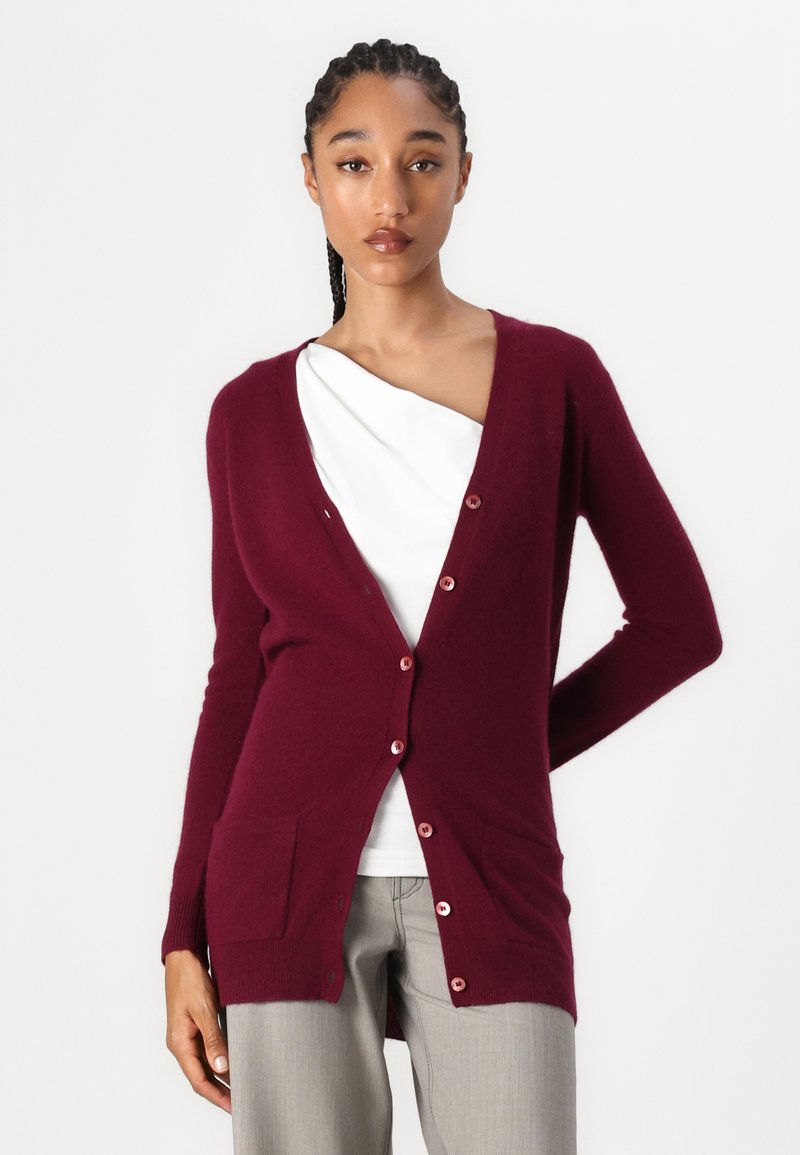 Burgunderfarbener Cardigan aus weichem Stoff, mit V-Ausschnitt, langen Ärmeln, zwei Vordertaschen und Knopfverschluss.