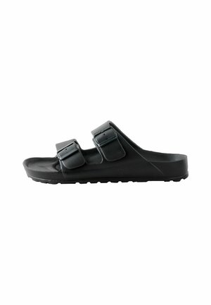 Sort slide sandal lavet af gummi med to justerbare stropper. Har en tekstureret sål og en tyk sål med mønster for godt greb.