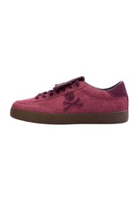 Nappasneakers i en djup burgundy färg med låg profil, som har en brun gummisula och en stickad dödskalle och korsben-logotyp.