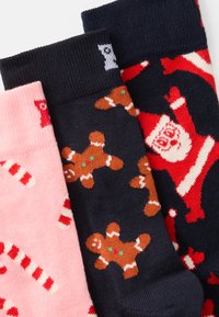 Kolm paar sokke: roosa piparkookide jahtidega, tume sinine piparkookide meestega ja mereväe sinine Jõuluvana mustriga. Kootud mustrid ribakujuliste ääredega.