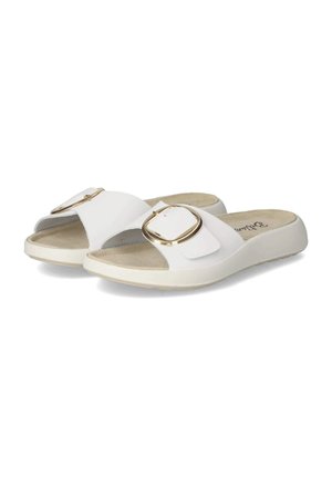 Witte slip-on sandalen met brede banden met grote gouden gespen en beige gevoerde binnenzolen, tegen een witte achtergrond.