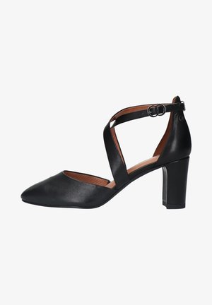 Chaussure à talon en cuir noir avec un bout pointu et un design de bride avec un détail de boucle. Le talon est épais et mesure environ 7,5 cm.