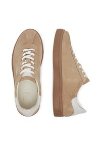 Beežid nahast tossud valgete kingapaeltega, pruunist kummist tallaga ja valge nahast aktsendiga kanna juures. Kujundatud madala profiiliga ja ümarate varvastega.