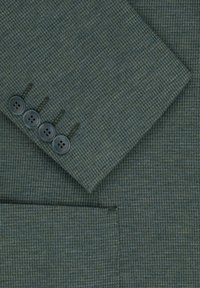 Ciemnozielony teksturowany materiał z wzorem w houndstooth, z mankietem zapinanym na guziki z czterema okrągłymi ciemnymi guzikami oraz boczną kieszenią.