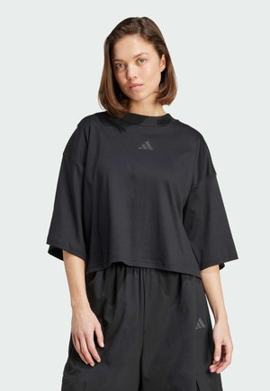 T-shirt corta nera realizzata in tessuto morbido, con scollo rotondo e maniche corte. Presenta un logo sobrio sul davanti.