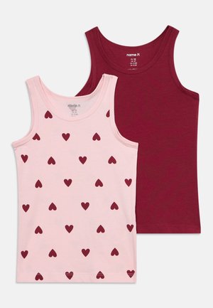 Zwei ärmellose Kinder-Tanktops, eines einfarbig dunkelrot und eines hellrosa mit dunkelroten Herzmustern, flach auf weißem Hintergrund gelegt.