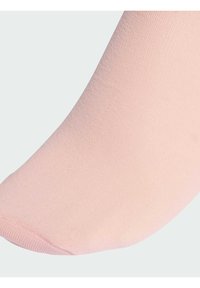 Svetloružová ponožka po členky s hladkou textúrou, rebrovaným manžetom a bezšvovým dizajnom prstov. Materiál vyzerá mäkko a pružne.