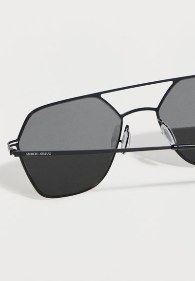 Μαύρα γυαλιά ηλίου με μεταλλικό σκελετό και εξαγωνικούς σκοτεινούς φακούς, διαφανείς ρυθμιζόμενες μύτες, λογότυπο Giorgio Armani στο αριστερό πλαϊνό μέρος.