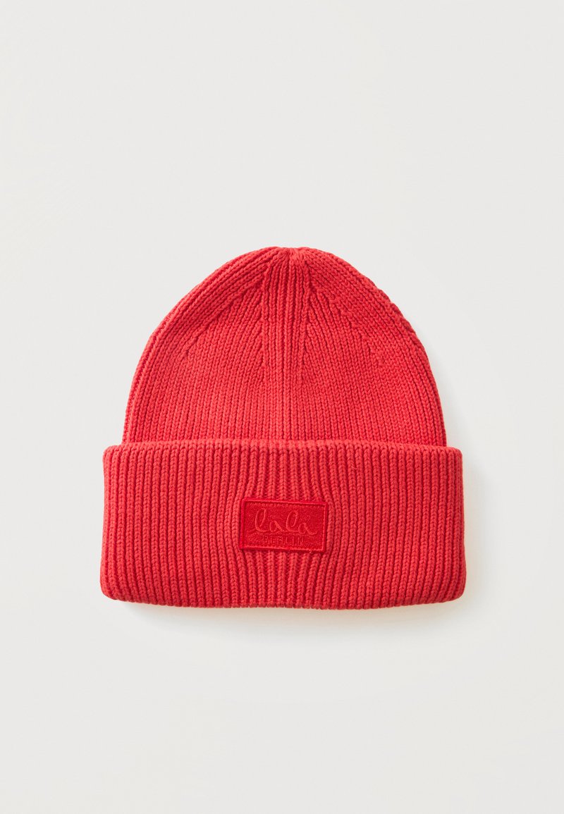 Bonnet en tricot côtelé rouge avec revers plié et petite étiquette rectangulaire à l'avant.