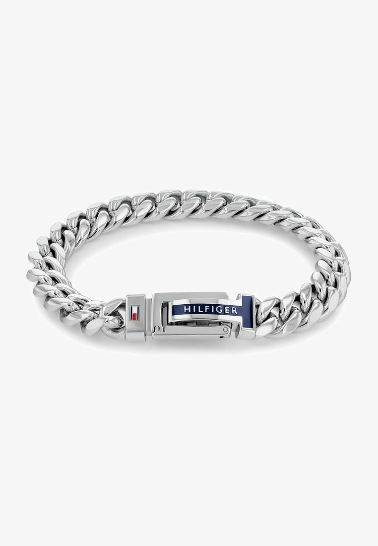 Sølv metallkjede armbånd med tykke lenker og en lås med en blå og hvit "HILFIGER"-logo. Glatt, polert tekstur.