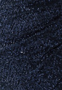 Navy blue fabric covered in small, shiny sequins, creating a textured, shimmering surface. The sequins vary in size, enhancing visual depth.